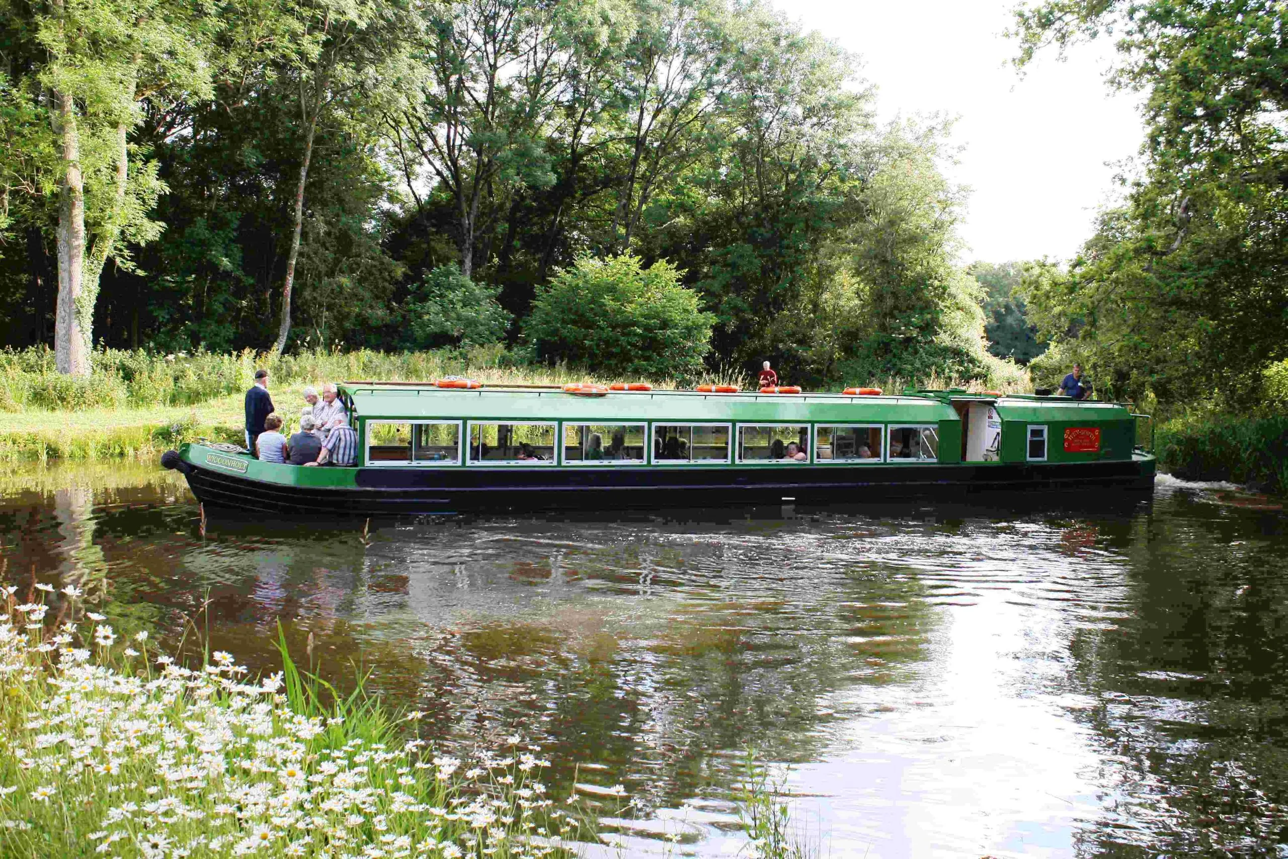 Passengers on a narrowboat cruise along the Wey and Arun Canal