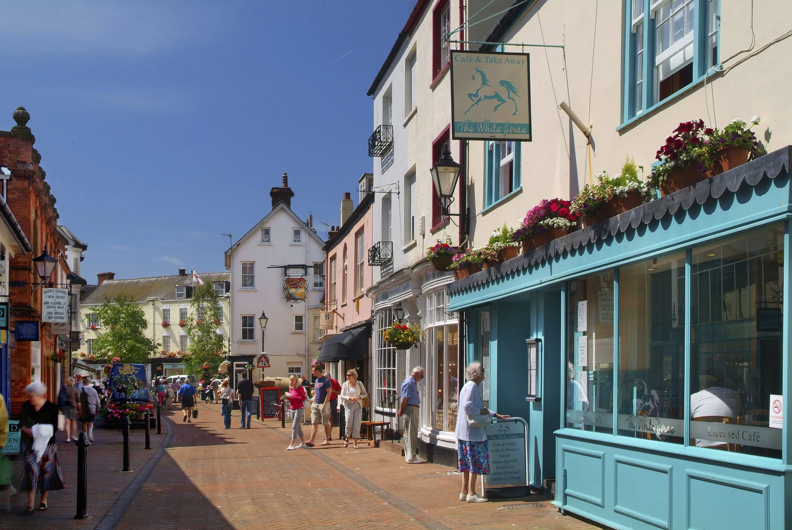 Shops and hanging baskets on a street in Sidmouth, Devon